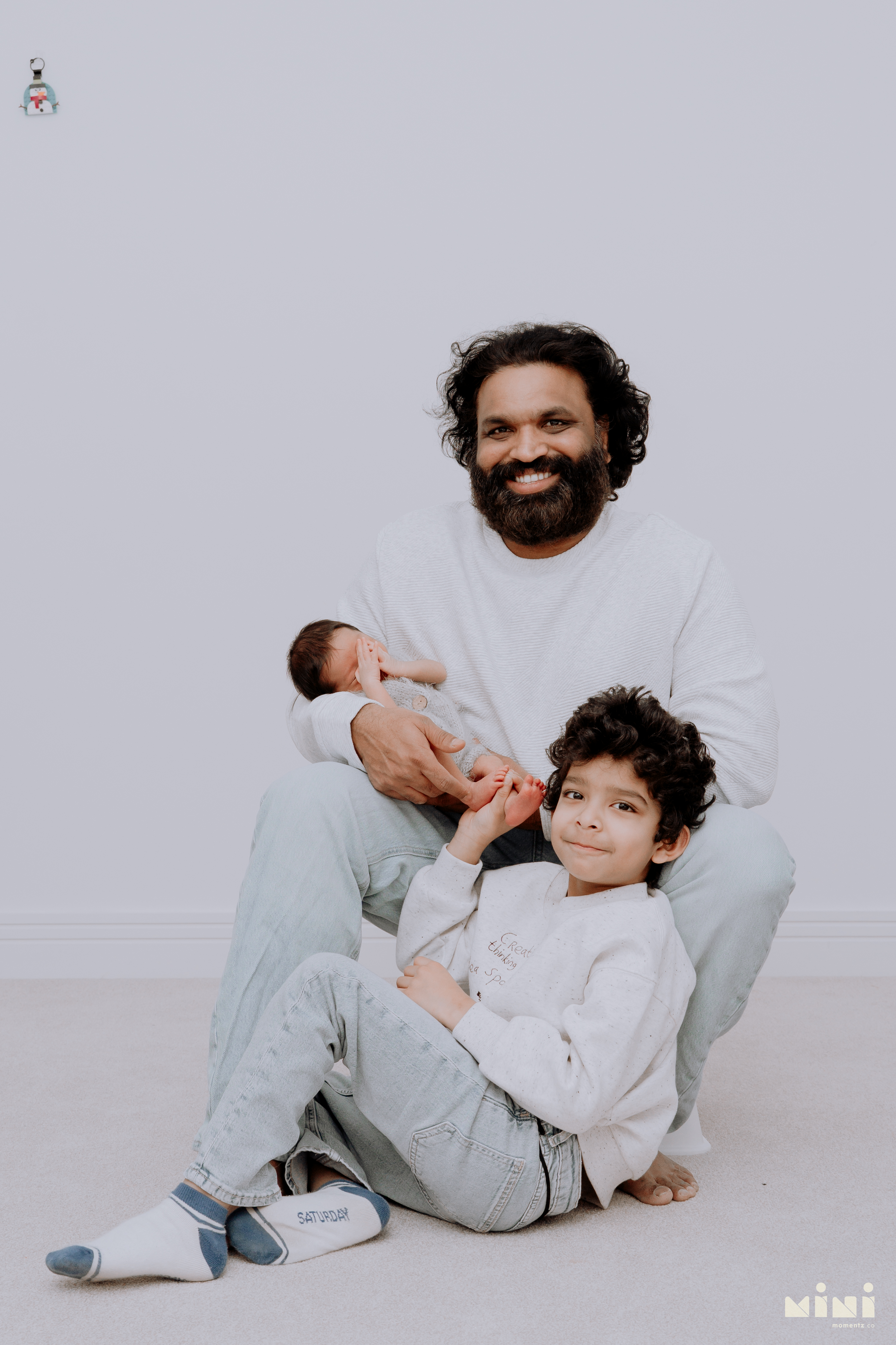 Chaithanya sitting with son Kiwi and his newborn daughter — father with both children during the MiniMomentz Edinburgh newborn photography session