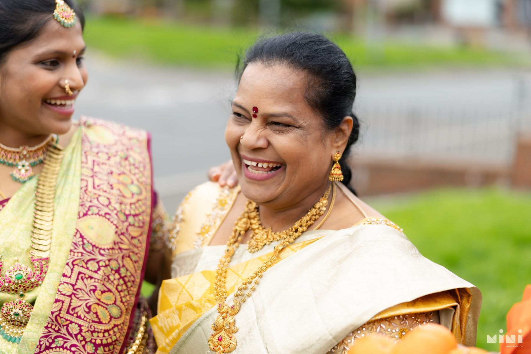 Divya sharing a joyful laugh with her mother outdoors
