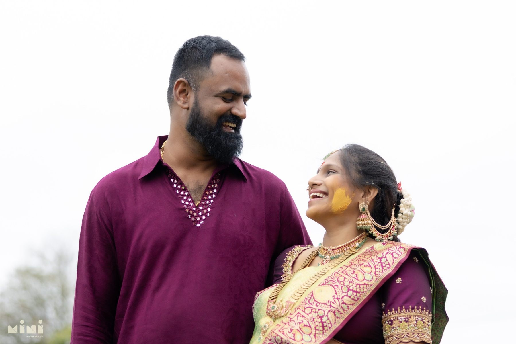 Divya and Ravi laughing together during their outdoor Seemantham maternity portraits