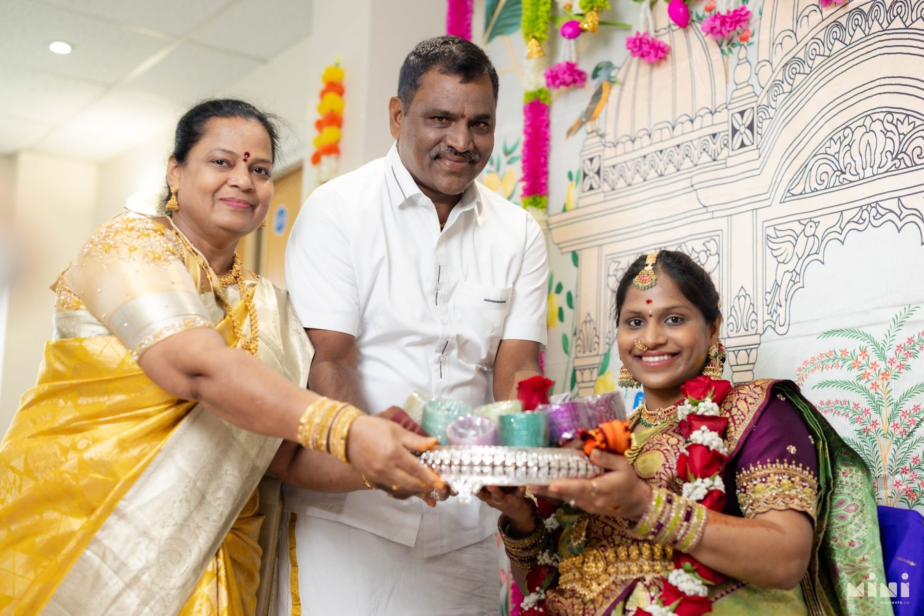 Divya with her parents sharing a happy moment during the ceremony